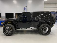 a black jeep is parked in a garage