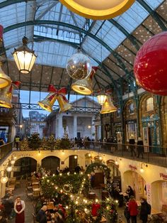 the inside of a shopping mall with christmas decorations and lights hanging from it's ceiling