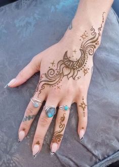 a woman's hand with henna tattoos on it