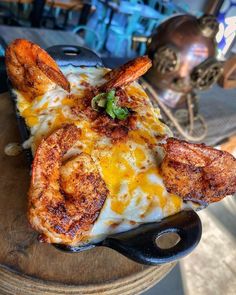 a piece of pizza with shrimp and cheese on it sitting on top of a table