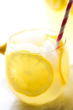 a glass filled with lemonade sitting on top of a table