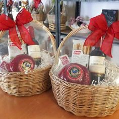 two baskets filled with wine and cheese on top of a table