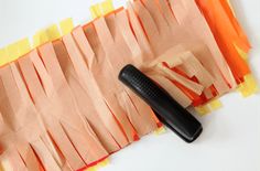 a black object laying on top of orange strips of paper