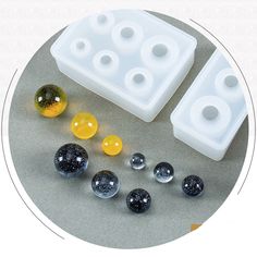 several different colored marbles are arranged on a circular table with an ice tray in the middle