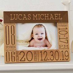 a baby's birth announcement frame with a teddy bear on the shelf next to it