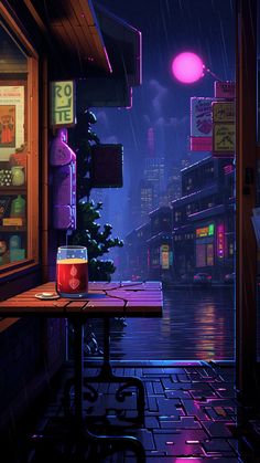 a table with a drink on it in front of a store window at night time