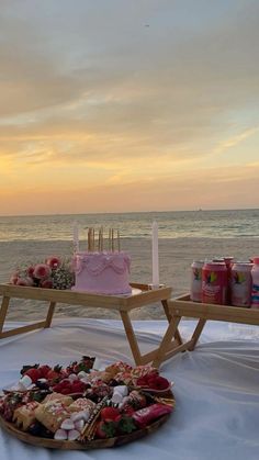 two trays filled with food sitting on top of a table next to the ocean