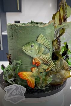 a green cake decorated with fish and plants