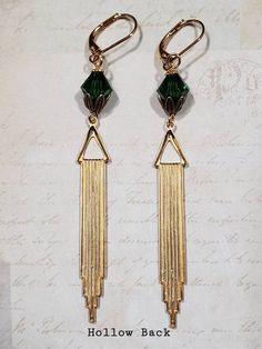 Textured Front, Hollow BackThese Art Deco style earrings feature beautiful green Swarovski crystals and long stamped brass Deco style pendants.The brass pendants have a ribbed texture on the front and the hollow reverse on the back (SEE 2nd PHOTO).The earrings measure 3 1/4 inches long and hang from gold plated leverback ear wires.ABOUT THIS COLLECTIONWhat are the three style essentials Jazz Age flappers like Clara Bow, Louise Brooks, and Zelda Fitzgerald have in common? Red lipstick, bobbed hai Green And Gold Art Deco, Green And Gold Art, Flapper Jewelry, Art Deco Jewelry 1920s, 1920s Earrings, Gold Art Deco Earrings, Gatsby Jewelry, Zelda Fitzgerald, 1920s Jewelry