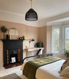 a bedroom with a bed, fireplace and windows on both sides of the window sill