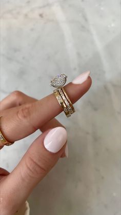 a woman's hand with two rings on her fingers and one ring in the middle