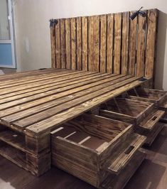 a bed made out of wooden pallets with drawers