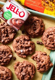 chocolate cookies are arranged on a tray next to a bag of jello and some chips