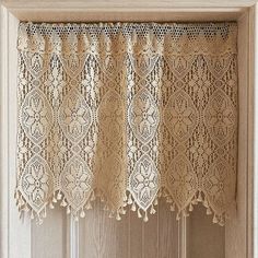 an old window with lace curtains hanging on it's side and the curtain is open