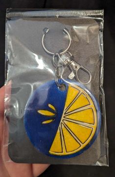 a blue and yellow keychain with an orange slice on it