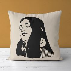 a black and white pillow with a drawing of a woman's face on it