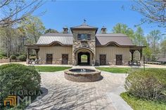 a large house with a fountain in front of it