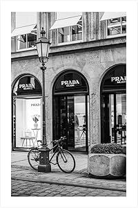 black and white photograph of a bicycle parked in front of a prada store