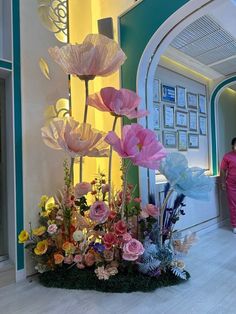 a woman is walking past a flower display