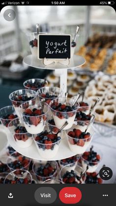 an assortment of desserts and pastries displayed on a table with a sign that says yogurt parfait