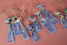 blue and white ceramic ornaments hanging from string on pink background with twine of twine