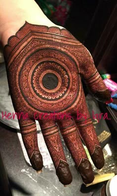 someone has their hand painted with henna designs