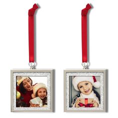 two christmas ornaments hanging from red ribbon on white background, one with santa's hat and the other with an ornament