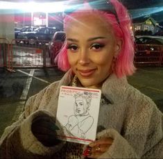 a woman with pink hair holding up a caricature