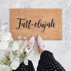 a woman standing next to a door mat that says hey there pumpkin