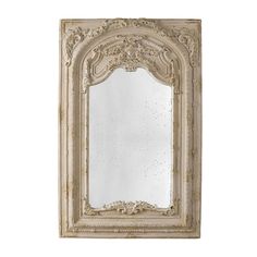 an ornate white framed mirror on a wall