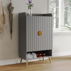 a gray cabinet with two pairs of shoes on it in front of a white wall