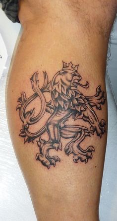 a man with a tattoo on his leg that has a lion and crown on it