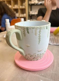 a coffee cup sitting on top of a pink saucer