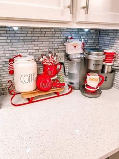 a kitchen counter with coffee maker, mugs and other items on top of it