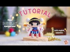 an image of a small doll on a wooden block with christmas lights in the background