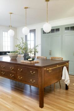 a large wooden table sitting on top of a hard wood floor covered in white walls