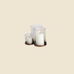 three white candles sitting on top of each other