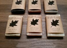 four bars of soap with maple leaves on them sitting on a wooden table top next to each other