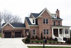 a large brick house with white trim and black shutters