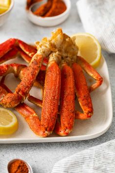 crab legs on a plate with lemon wedges