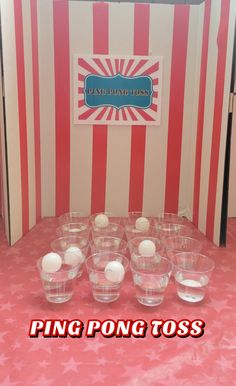 there are many glasses with balls in them on the table next to a striped wall