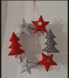 a christmas wreath with red, white and grey stars hanging from the front on a wall