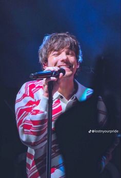 a man standing in front of a microphone on stage