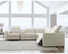 a living room with white furniture and large windows