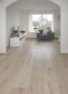 an empty living room with white walls and wood flooring is pictured in this image