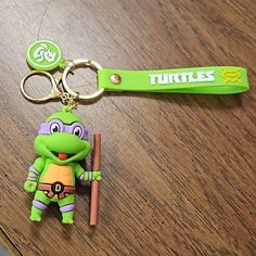 a keychain with a teenage mutant holding a baseball bat on top of a wooden table