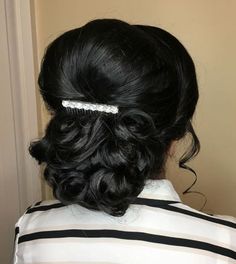 the back of a woman's head wearing a comb in her hair with wavy black hair