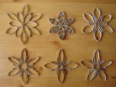 four metal snowflakes sitting on top of a wooden table