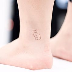 a small tattoo on the ankle of a woman's foot, depicting a rabbit