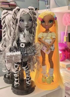 two dolls sitting next to each other on a table